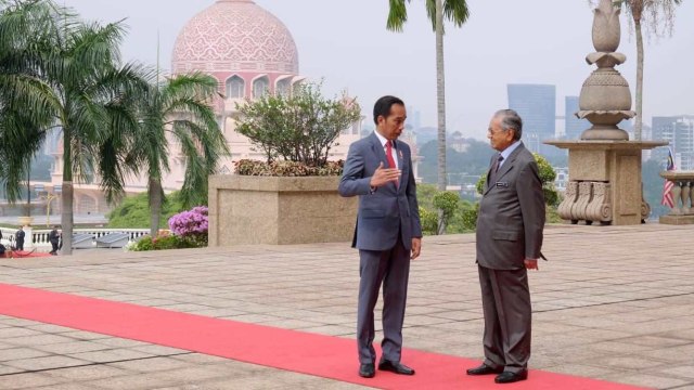 Presiden Joko Widodo (kiri) berbincang dengan Perdana Menteri Malaysia Mahathir Mohamad di Dataran Perdana, Putrajaya, Malaysia. Foto: Dok. BPMI Setpres/Muchlis Jr