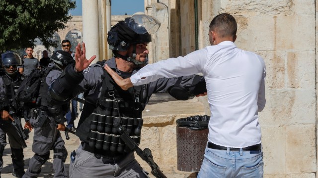 Seorang tentara Israel berkelahi dengan seorang warga Palestina di kompleks Masjid al-Aqsa di Kota Tua Yerusalem, Minggu (11/8). Foto: AFP/AHMAD GHARABLI