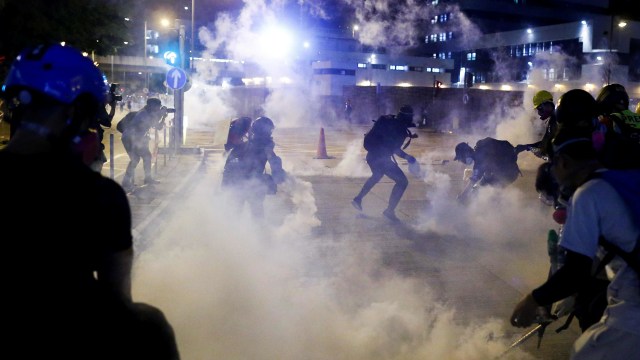 Petugas kepolisian melempari gas air mata ke massa demonstrasi di Hong Kong. Foto: Reuters