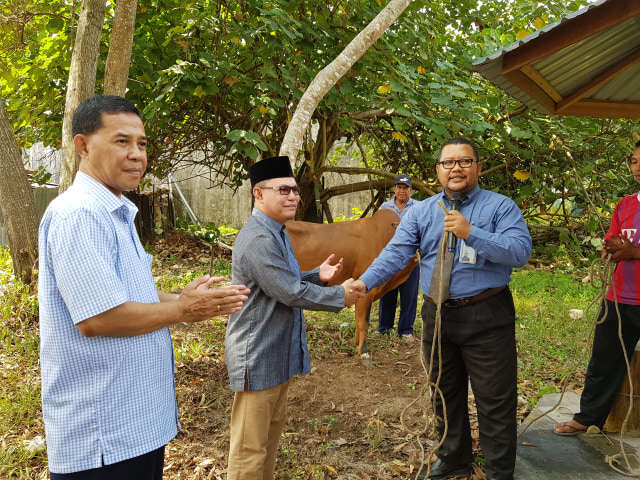 Branch Manager Office BSM Pangkalan Bun Zaenal Arifin (kanan)menyerahkan bantuan hewan kurban kepada Ketua Yayasan Kotawaringin Ujang Iskandar (tengah). (Foto: Joko Hardyono)