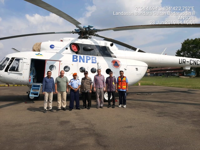 Satgas Karhutla BPBD Sumsel bersama tim dari Rusia berpose di belakang helikopter MI-8 (Foto: BPBD Sumsel)