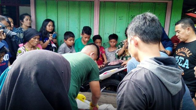 Warga menyaksikan proses evakuasi jasad bayi yang ditemukan hanyut di aliran sungai di Kelurahan Binuang, Kampung Dalam, Kota Padang (Foto: Irwanda / Langkan.id)