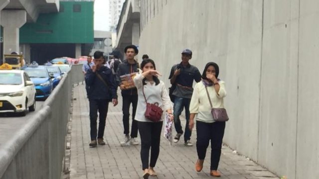 Pejalan kaki di trotoar Stasiun MRT Lebak Bulus menutup hidungnya karena bau pesing yang cukup menyengat Foto: Andesta Herli/kumparan