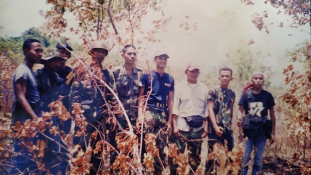 Eks kombatan GAM di lokasi bombardir pesawat tempur, saat konflik Aceh. Tampak daun-daun besar terbakar. Foto repro: acehkini/Dok. Irwansyah  