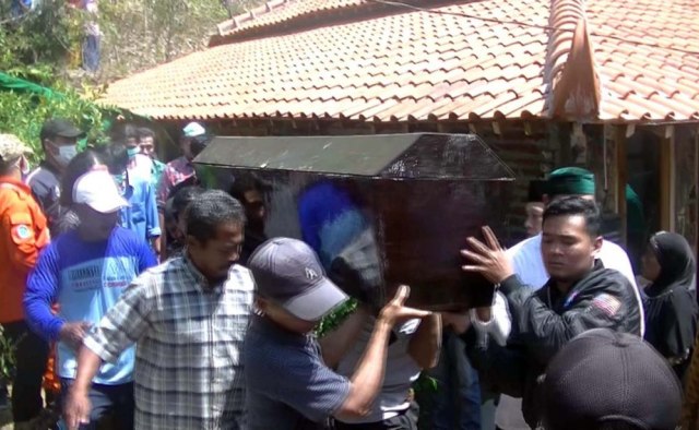 Proses pembongkaran makam dan pemindahan jenazah Suyat Suyono di Desa Pelem, Kecamatan Campurdarat, Kabupaten Tulungagung.