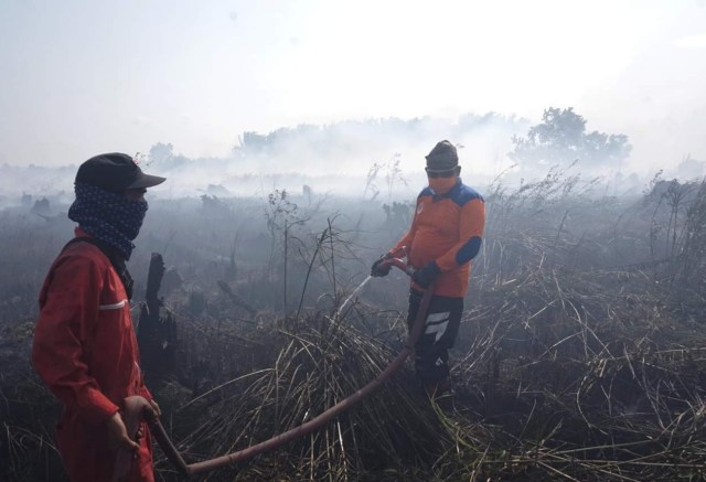 Wakil Bupati Kobar Ahmadi Riansyah saat memadamkan api di Desa Sungai Tendang. (Foto: Prokom Kobar)