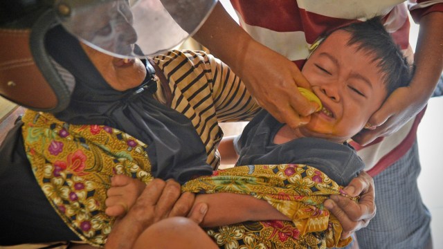 Seorang anak menangis saat diberikan jamu cekok Krekop. Foto: Fanny Wardhani/kumparan