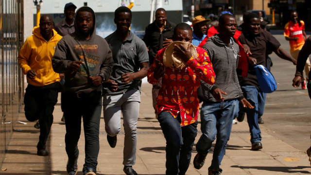 Pengunjuk rasa melarikan diri setelah polisi menembakkan gas air mata di Harare, Zimbabwe. Foto: REUTERS/Philimon Bulawayo