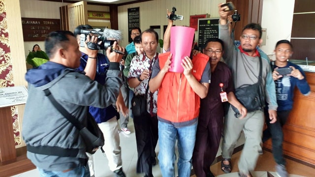 Staf Kejari Rembang yang tilap uang tilang menutup wajahnya. Foto: Dok. Istimewa