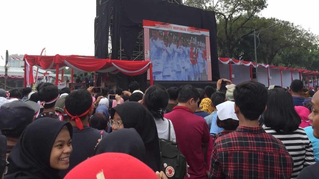 Masyarakat menyaksikan Upacara Peringatan Proklamasi melalui layar besar di seberang Istana Merdeka. Foto: Ricky Febrian/kumparan