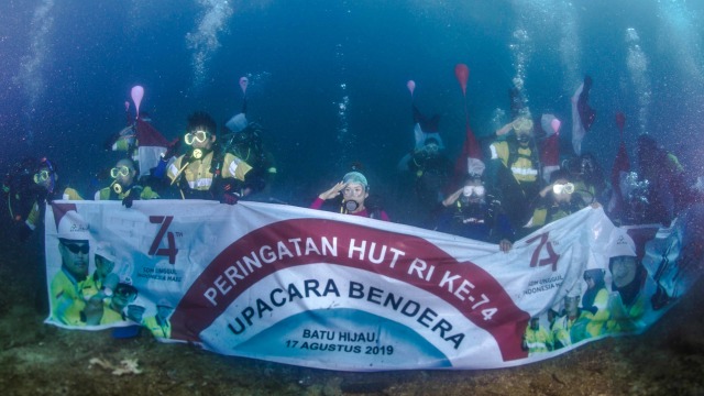 Penyelam mengibarkan Bendera Merah Putih di bawah laut Perairan Teluk Benete, Sumbawa Barat. Foto: Amman Mineral -@yudhincex12.