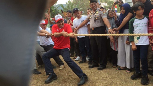 Gubernur DKI Jakarta Anies Baswedan mengikuti lomba tarik tambang di Lapangan RW 04 Cilandak, Jakarta Selatan. Foto: Paulina Herasmarindar/kumparan