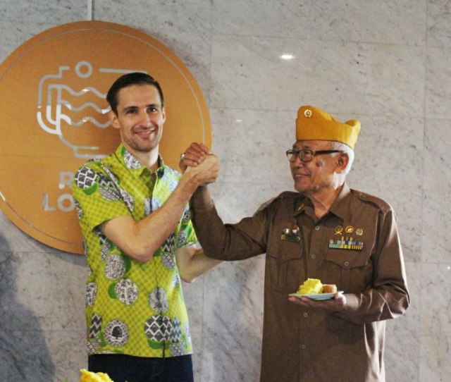 General Manager Harris Hotel & Conventions Malang Romain Huet (kiri) foto bersama dengan veteran usai acara pengibaran bendera merah putih di hotel tersebut.(foto dokumen).