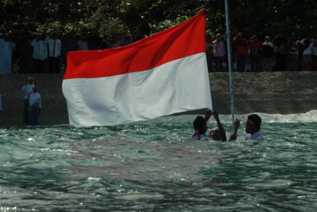 Detik-detik pengibaran bendera merah putih di laut, pesisir pantai Kelurahan Bobo, Tidore Utara, Kota Tidore Kepulauan, Maluku Utara. (Istimewa)