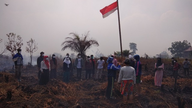 Pengibaran bendera merah putih di lokasi kebakaran lahan di Kota Palangka Raya. (Foto: @InfoPLK)
