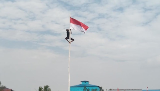 Aksi Joni Iskandar, siswa sekolah di Kayong Utara, Kalbar, saat panjat tiang bendera Foto: Istimewa