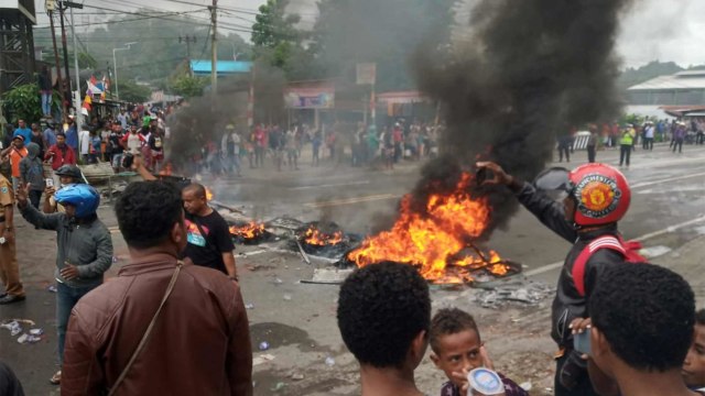 Pengunjuk rasa membakar ban saat aksi massa di Manokwari, Papua, pada Senin (19/8). Foto: AFP