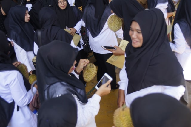 Para CPNS Kemenag Aceh yang baru mendapatkan SK pengangkatan memegang durian pada pesta makan durian  bareng di Kantor Kemenag Aceh, Banda Aceh, Senin (19/8). Foto: Dok. Kemenag Aceh