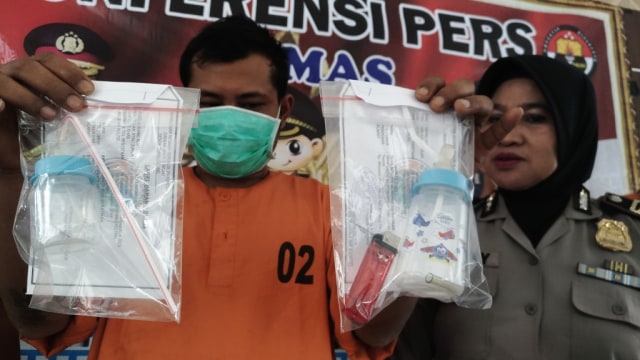 Tersangka Novi Solivin (31) alias Nopek, berikut barang bukti berupa dot bayi yang digunakan sebagai alat hisap sabu, ditunjukkan kepada awak media di Mapolres Temanggung, Kamis (22/8/2019). Foto: ari.