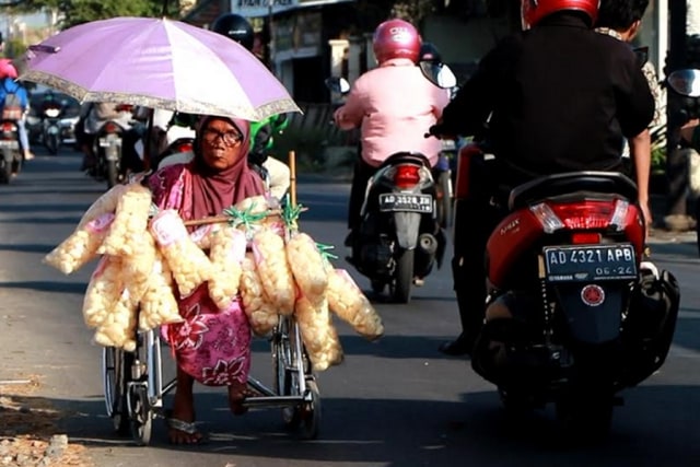 Nenek Suminah saat berjualan kerupuk menggunakan kursi roda (Tara Wahyu)