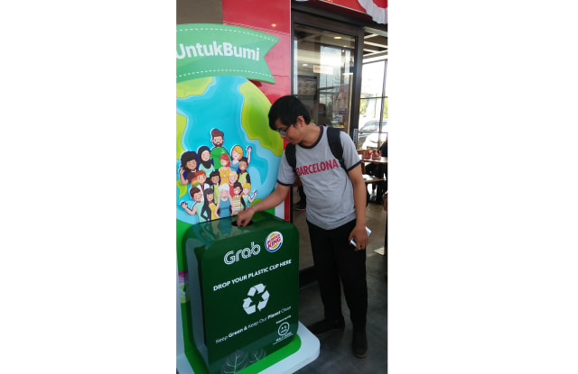 Seorang pengunjung Burger King membuang sampah plastik di dropbox yang disediakan Grabfood (kanalbali/GAN)