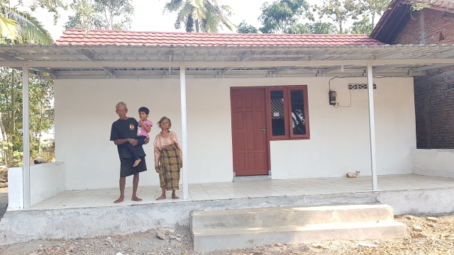 Kakek Parimin sedang menggendong Cindy dan Nenek Tukiyem di rumah barunya, Senin (19/8/2019). Foto: adn.