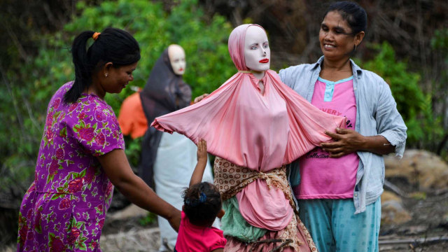 Petani memasangkan pakaian ke maneken di tengah lahan perkebunannya di Lamteuba, Aceh Besar, Aceh, Senin (26/8/2019). Foto: AFP/CHAIDEER MAHYUDDIN