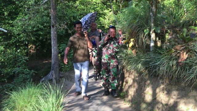Anggota TNI memanggul pria tua pengidap strok saat proses evakuasi warga akibat adanya guguran lava Gunung Karangetang di Siau Tagulandang Biaro (Sitaro), Sulut, yang mendekati permukiman.