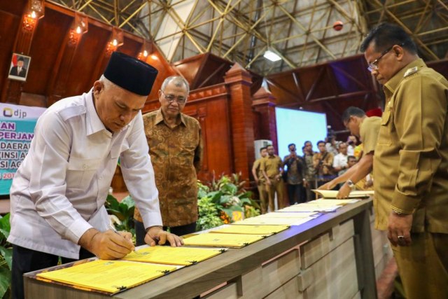 Sekda Aceh, Taqwallah menandatangani kerja sama optimalisasi pendapatan disaksikan Ketua KPK, Agus Rahardjo. Foto: Suparta/acehkini