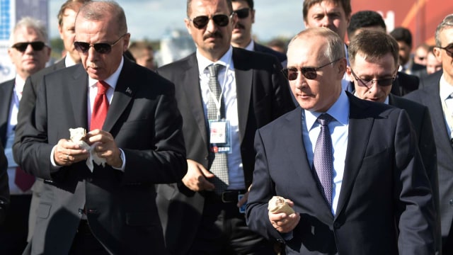Presiden Turki Recep Tayyip Erdogan (kiri) dan Presiden Rusia Vladimir Putin makan es krim saat mengunjungi pembukaan MAKS-2019 di Zhukovsky di Moskow. Foto: AFP/Alexey NIKOLSKY