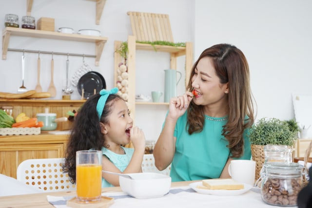 Ilustrasi ibu dan anak sedang menikmati camilan. Foto: Shutterstock