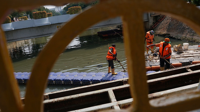 Kegiatan pasukan oranye membersihkan sampah plastik yang mengapung di aliran anak Kali Ciliwung, Pasar Baru, Kamis (29/8). Foto: Fanny Kusumawardhani/kumparan