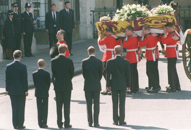 Pangeran Charles, Pangeran Harry, Earl Spencer, dan Pangeran William menyaksikan peti jenazah Putri Diana diturunkan dari kereta kuda. Foto: Joel Robine/ AFP WPA POOL/ AFP