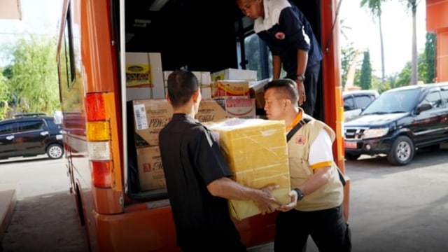 Kepala Bidang Kedaruratan dan Logistik Badan Penanggulangan Bencana Daerah (BPBD), Sumatera Barat, Rumainur mengangkut bantuan randang yang hendak dikirim ke lokasi bencana. (Foto: Anto Jambak/Langkan.id)
