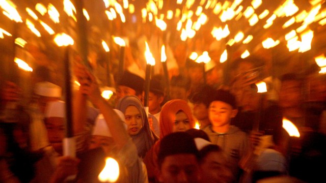 Warga membawa obor ketika mengikuti pawai menyambut Tahun Baru Islam di Jalan Raya Puncak, Bogor, Jawa Barat. Foto: ANTARA FOTO/Yulius Satria Wijaya