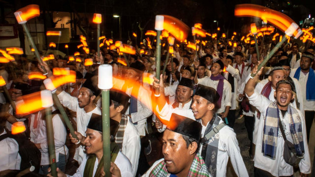 Sejumlah warga dengan membawa obor elektrik mengikuti Jakarta Muharram Festival di Jalan MH Thamrin, Jakarta. Foto: ANTARA FOTO/Aprillio Akbar