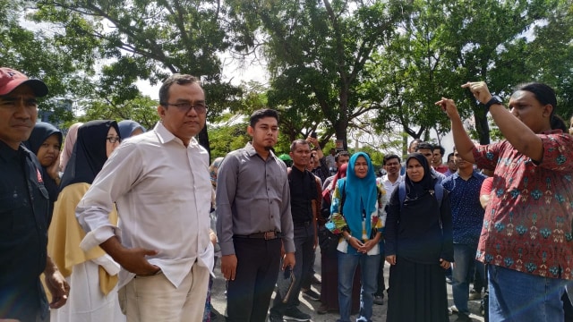Saiful Mahdi (baju putih) diantar puluhan aktivis ke kantor Polresta Banda Aceh, untuk menjalani pemeriksaan. Foto: Adi Warsidi/acehkini 