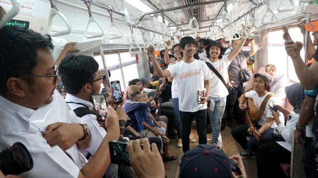 D'masiv menghibur penumpang di KRL dari Stasiun Juanda menuju stasiun Manggarai dan selanjutnya menuju Stasiun Jakarta kota. Foto: Iqbal Firdaus/kumparan