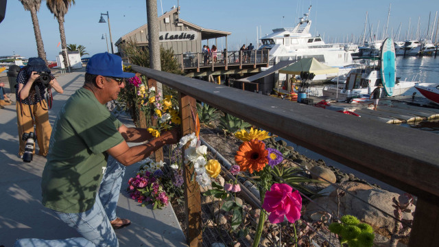 Seorang warga menaruh bunga untuk mengenang korban kapal tenggelam Foto: AFP