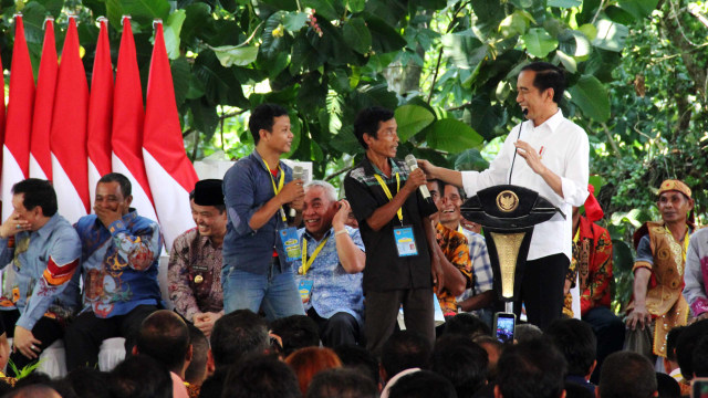 Presiden Joko Widodo (kanan) berbincang dengan warga saat penyerahan sertifikat Tanah Obyek Reforma Agraria (TORA) di Hutan Lindung Digulis, Pontianak, Kalimantan Barat, Kamis (5/9). Foto: ANTARA FOTO/Jessica Helena Wuysang