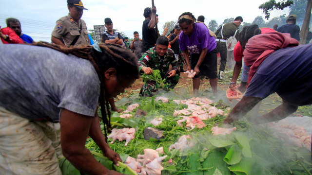 Masyarakat Papua melakukan upacara bakar batu di lapangan Hawai, Sentani, Papua. Foto: ANTARA FOTO/ Gusti Tanati