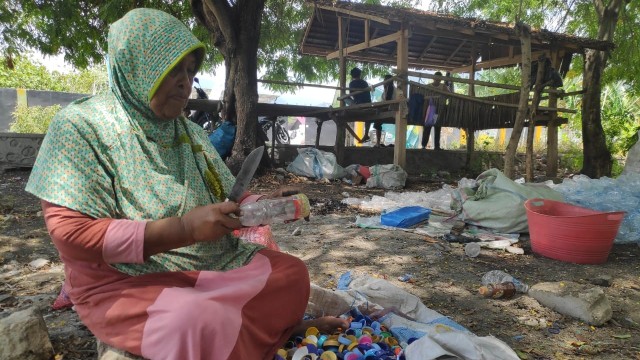 Suriyah (68), penyintas bencana Palu, membersihkan bekas plastik yang kemudian diolah. Foto: Ikram/PaluPoso 