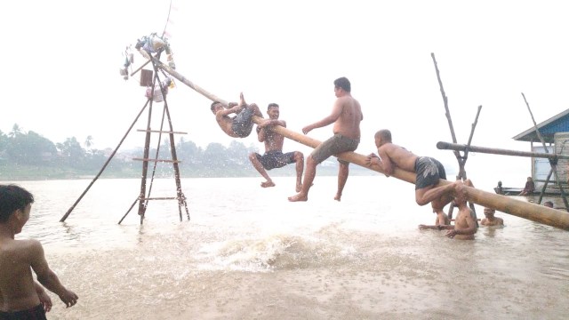 Kemeriahan lomba panjat pinang yang digelar warga di bantaran Sungai Melawi, di Kelurahan Ladang, Kecamatan Sintang, Kabupaten Sintang, Kalbar. Foto: Agus Pujianto/Hi!Pontianak