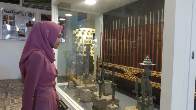 Salah satu pengunjung menikmati keindahan koleksi di Museum Ganesya Kota Malang. (Foto: Hafis Iqbal/Tugu Malang) 