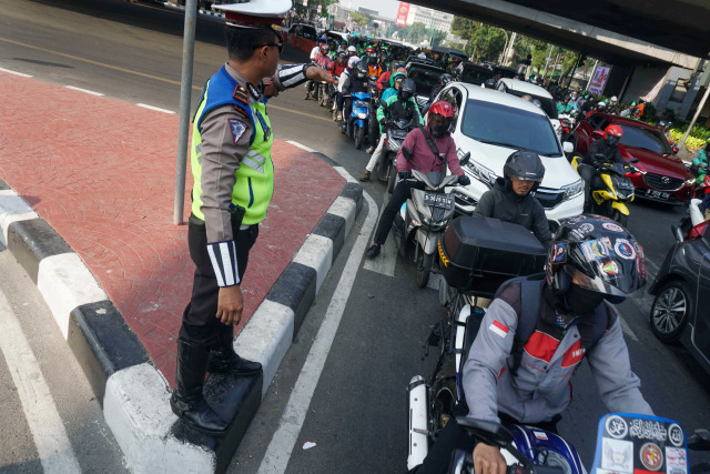 Polisi mengatur lalu lintas di kawasan  ganjil-genap di Jalan H. Rasuna Said, Jakarta Selatan. Foto: Irfan Adi Saputra/kumparan