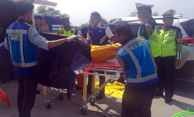 Petugas mengevakuasi jasad salah satu penumpang Toyota Rush yang menabrak truk boks di Tol Sumo.