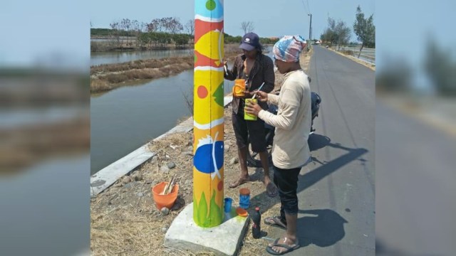 Warga Desa Kaliwlingi, Brebes melukis tiang listrik untuk menghindari gangguan iklan. (Foto: Dok. Mashadi) 