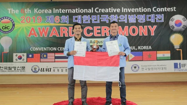 DUA mahasiswa Universitas Riau, Firman Edi dan Herfan Riansyah Pratama, membentanhkan bendera merah putih di Korea Selatan. 