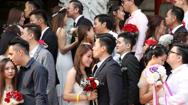 Pasangan pengantin baru berfoto bersama saat pernikahan massal Etnis China di Kuala Lumpur, Malaysia, Senin (9/9). Foto: REUTERS/Lim Huey Teng