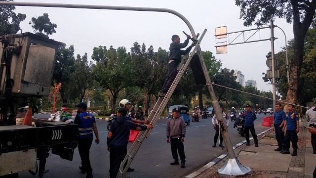 Proses pelepasan traffict light yang terkena bus di depan Balai Kota, Jakarta. Foto: Dok. Istimewa